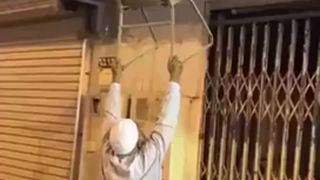 Graban a un anciano haciendo de todo por auxiliar a un gatito varado en el tejado