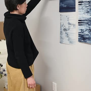Artist Hanging Pictures on Wall
