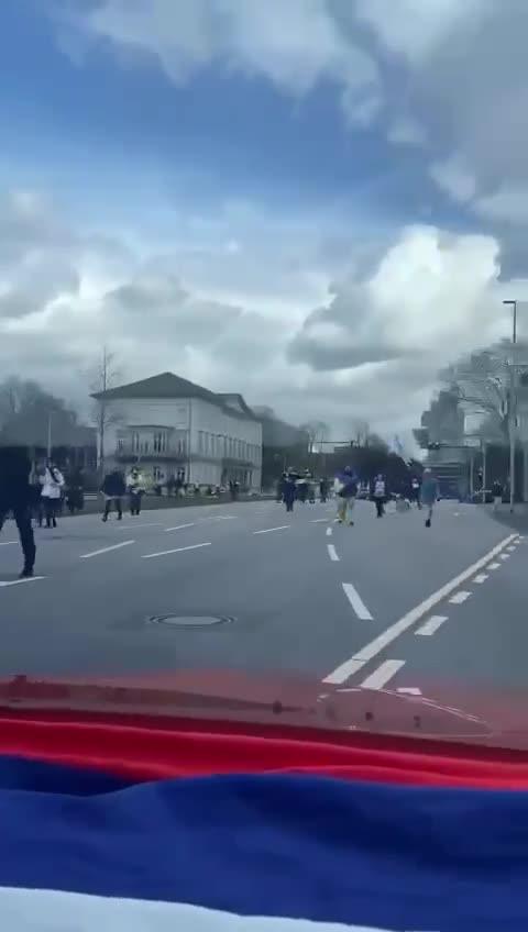 Germany, Russians in the car have their flag on the dashboard and bump into a pro-Ukrainian demo