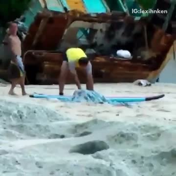 Guy yellow shirt kicking sand out of the way at beach