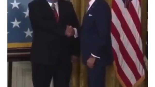 Biden puts the medal on backwards