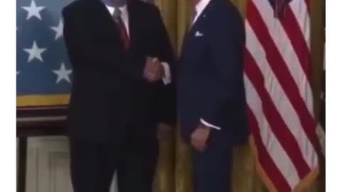 Biden puts the medal on backwards