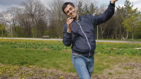 Man runs happy with a flower in the park