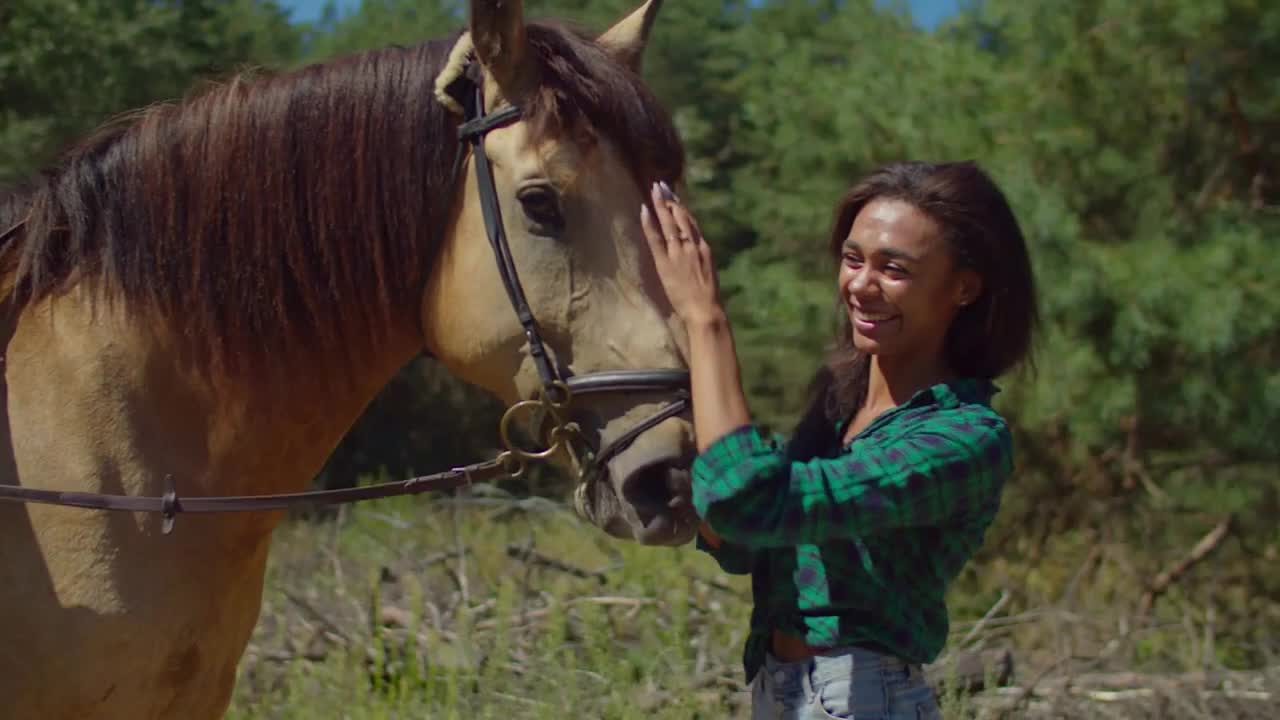 Cheerful attractive african american horsewoman in casual clothes