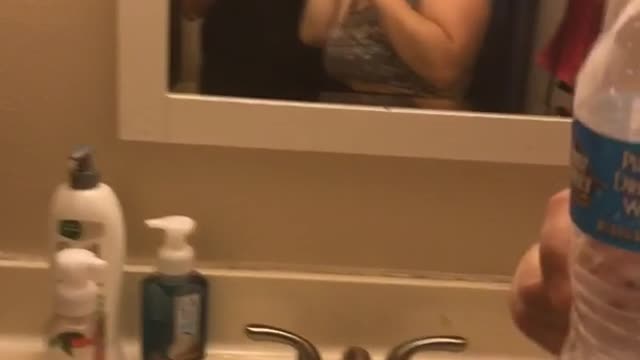 Two drunk girls one with water talking about makeup in restroom