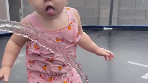 This little girl tries to get a drink from the water