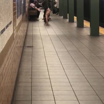 Shirtless long hair guy upside down handstand subway