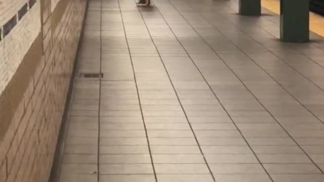 Shirtless long hair guy upside down handstand subway