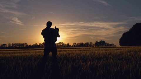 Man holding best friend. Silhouettes men with dog standing at wheat field at sundown