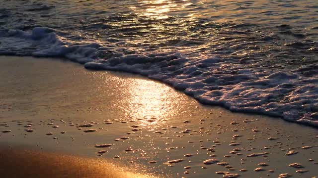 Calm waves wash over the warm sand