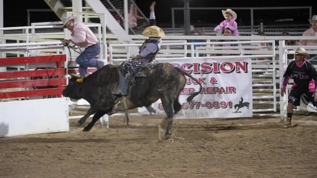 Editorial cowboy riding a big bull at the PRCA Oakley rodeo slow motion