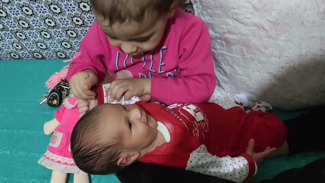 Loulou kisses her sister Maria and plays with her