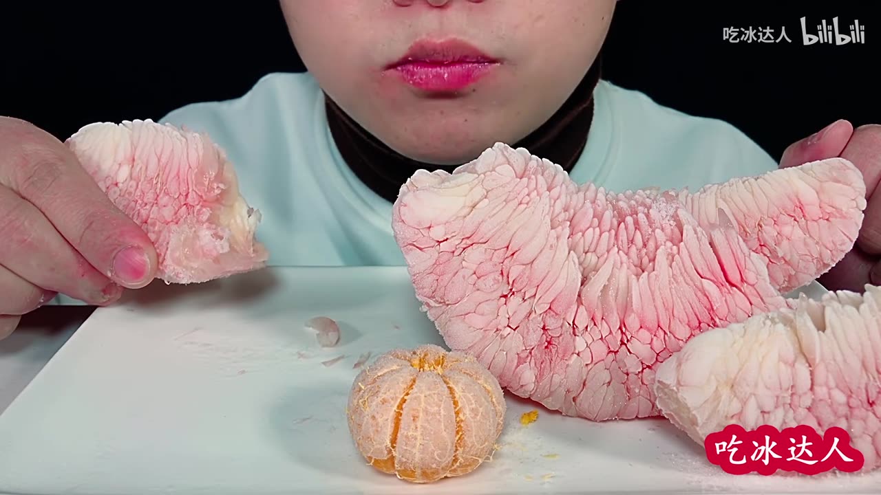 Guy eats frozen red grapefruit for two days and two nights on a cold day, looks at it all shivering