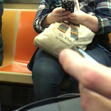 Lady chewing on her tan bag on phone