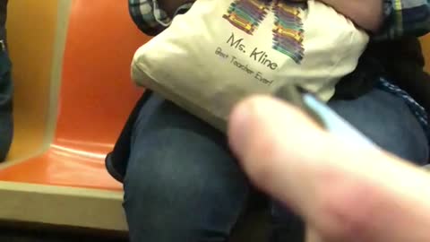 Lady chewing on her tan bag on phone 