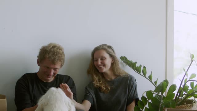 Couple Having Fun With Their White Dog