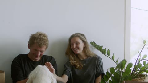 Couple Having Fun With Their White Dog