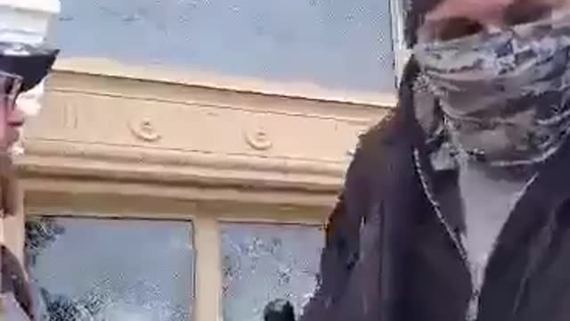 Protester using baton to smash Capitol Window