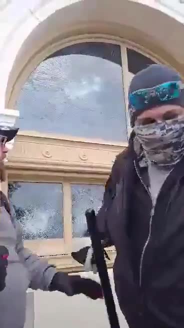 Protester using baton to smash Capitol Window