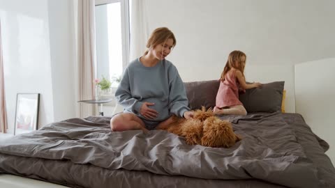 Mother Holding the Tummy while Playing the Dog