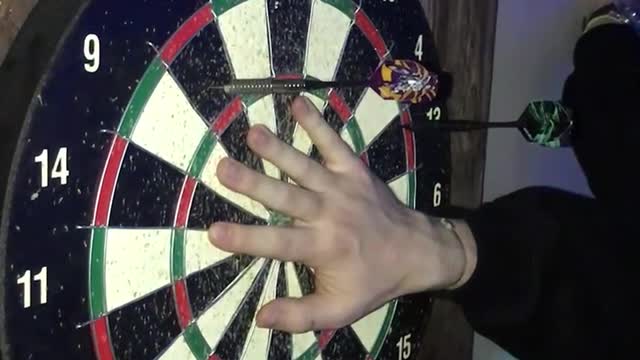 Man shooting dart on his friend’s hand