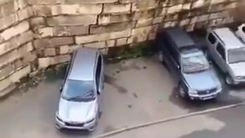 Woman Notices Something Wrong With The Wall Behind Her Car!