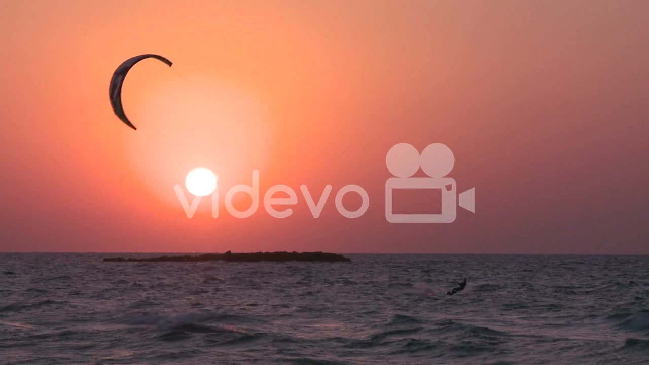 A windsurfer moves along a coastline at sunset 4