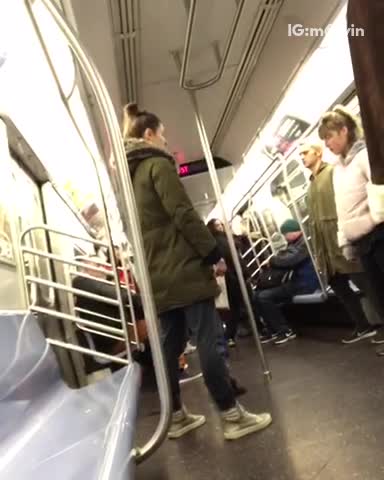 Four passengers stand still on subway train eyes closed