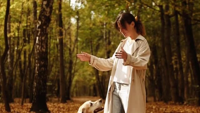 Young Woman Playing with Her Dog Outdoors