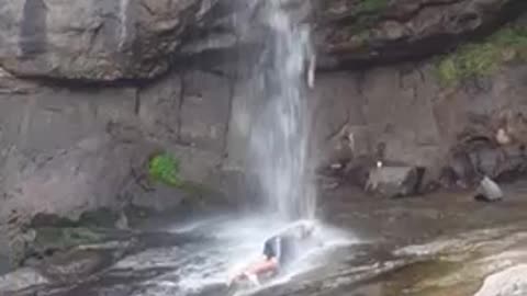 He's crazy! Look at him under the waterfall!