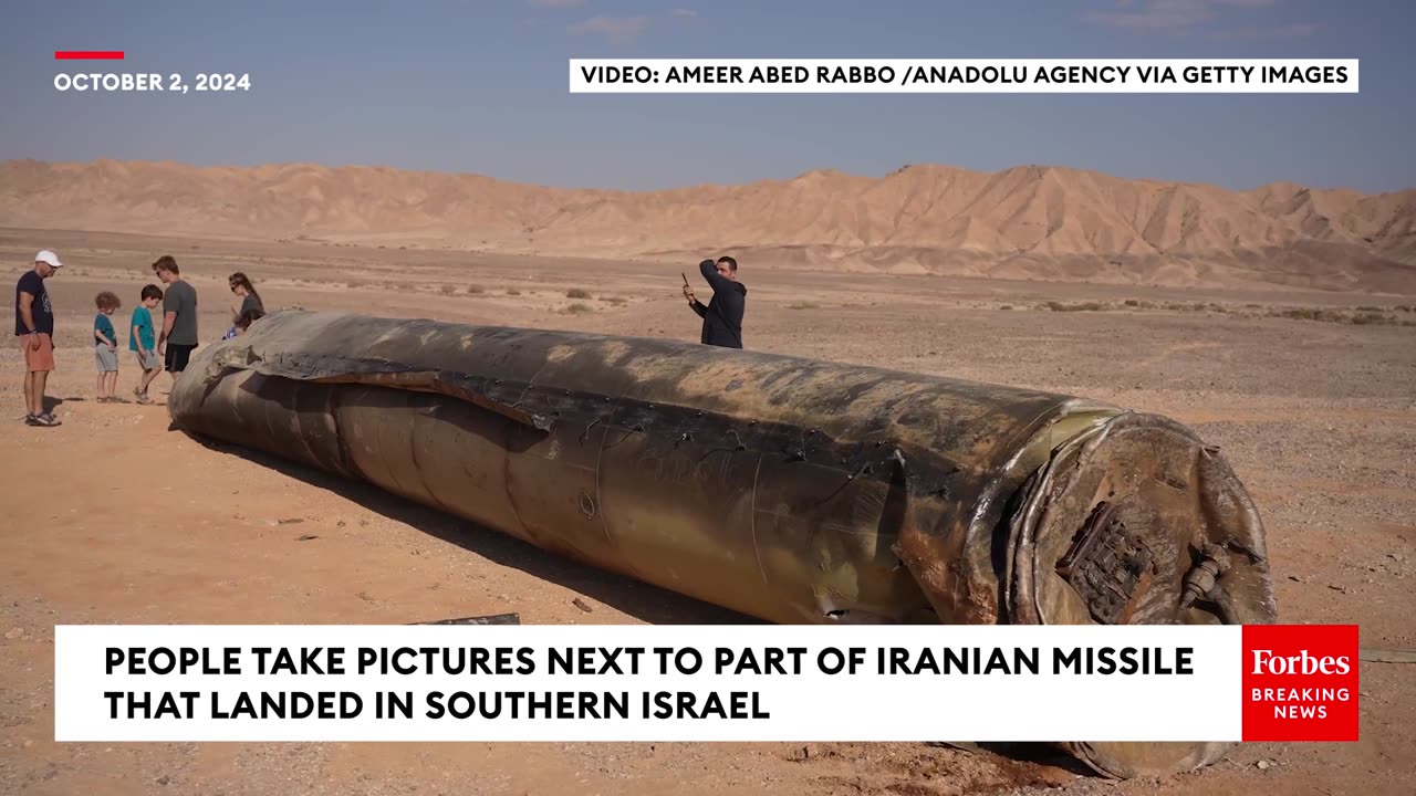 People Take Pictures Next To Remnants Of Iranian Missile That Landed In Southern Israel