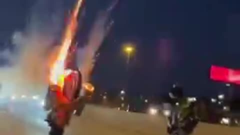 Pulls a Wheely on a Bike with Fireworks Attached to the Sides