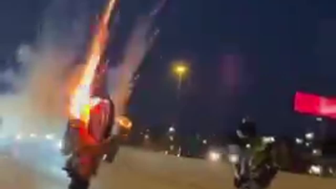 Pulls a Wheely on a Bike with Fireworks Attached to the Sides