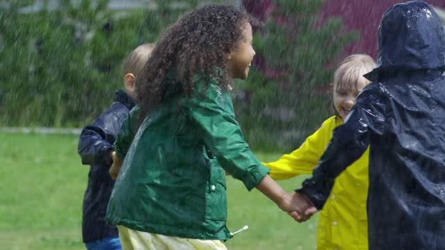 Children playing in a park wet in the rain