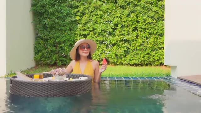 Beautiful Young Asian Woman Enjoying A Floating Breakfast In The Swimming Pool