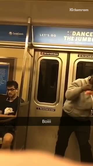 Guy in grey sweatshirt pretends to box on subway
