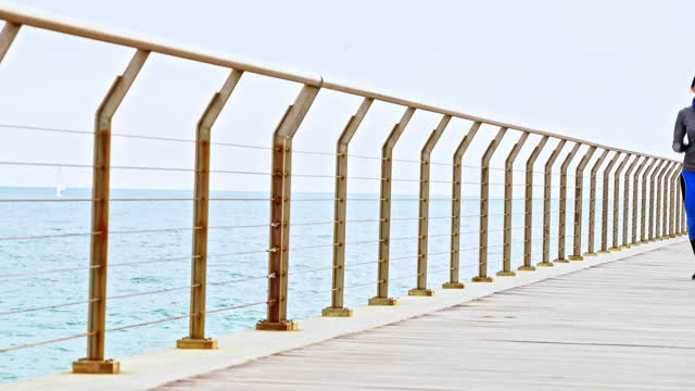 Athlete young woman running on pier