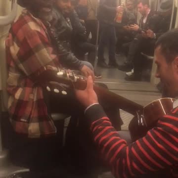 Old sunglasses man sings with guitar on subway