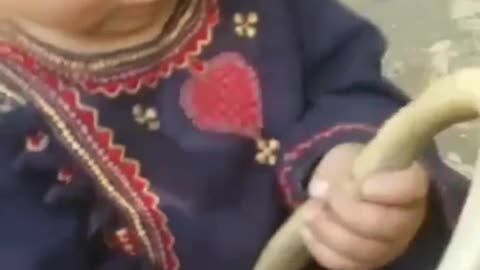 Little boy is not afraid of a cobra and tries to eat a snake