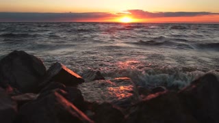 Red sky over a rocky seashore.