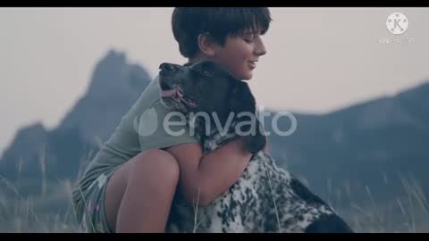 A Boy Hugs His Spotted Dog against the bsck Drop of Mountain.