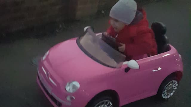 Adorable little girl enjoys driving her car