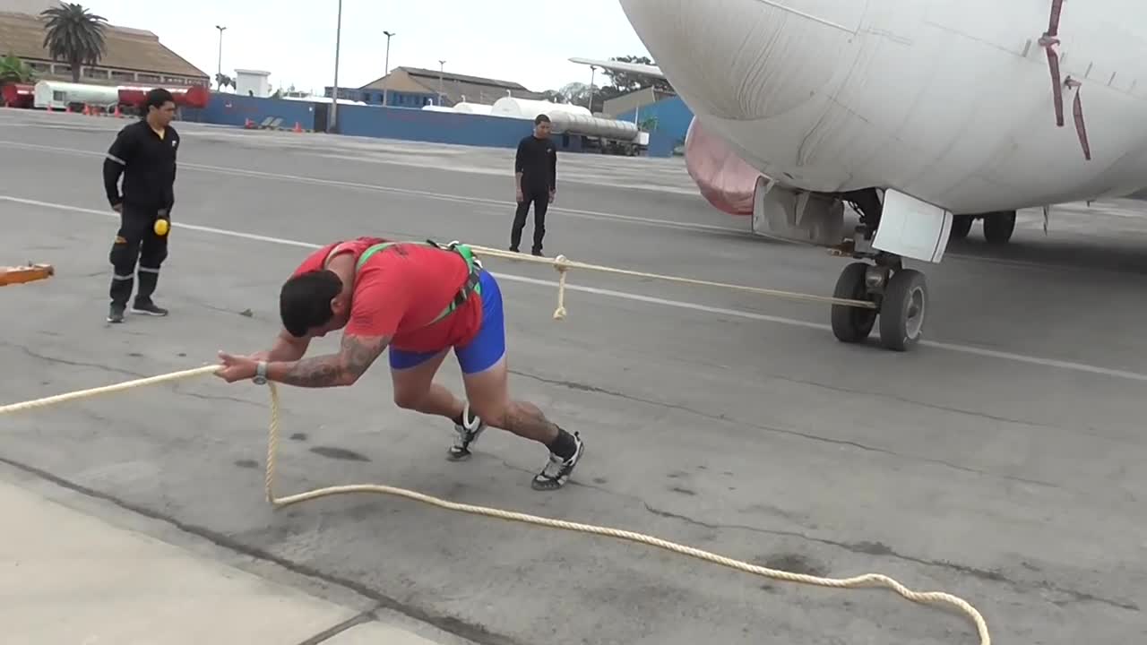 Hombre usa su fuerza para jalar un avion