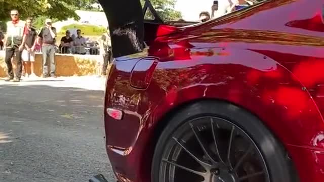 A modified rear wing car at the auto show attracts onlookers