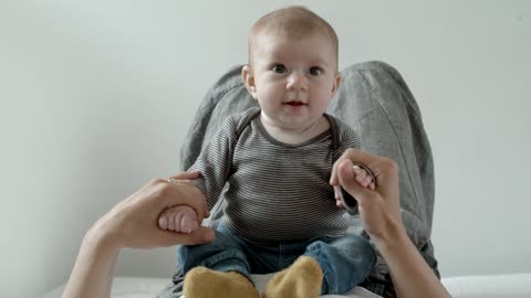 Baby on the belly of his mother plays and smiles