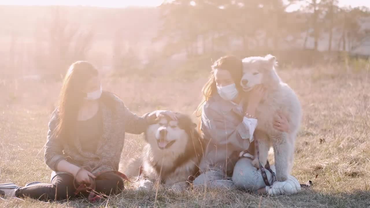 2 women play with dog