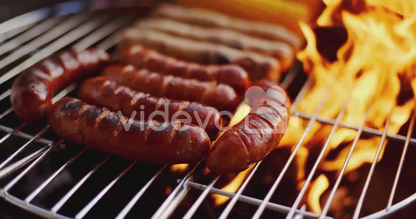 Sausages grilling over the flames