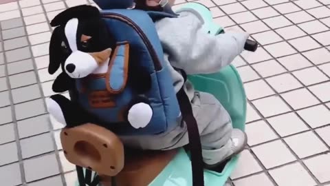 Baby going for a joy ride on his scooter