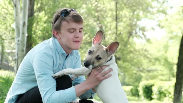 Puppy kisses the owner and hugs. Puppy licks the owner