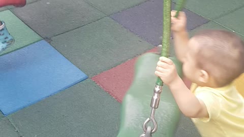 The child is playing on the swing.